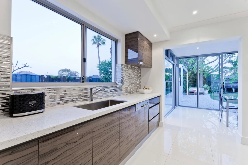 Bright kitchen with wooden cabinets by a large window